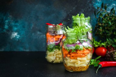 Kavanozda sağlıklı salata (sebzeli makarna salatası) menü kavramı. Yemek geçmişi. Üst Manzara. Boşluğu kopyala