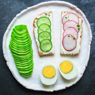 Sandviç, atıştırmalık sebzeler, kahvaltıda sağlıklı turp, salatalık, avokado, yumurta menüsü konsepti. Yemek geçmişi. textketo ya da paleo diyeti için üst görünüm kopyalama alanı
