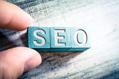 Tahta bloklardaki kelime Seo ve masadaki erkek parmakları tarafından düzenlenmiştir.