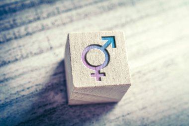 Transgender, LGBT or Intersex Icon With Combined Male And Female Sign On A Wodden Block On A Table clipart