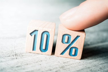 Ahşap bloklar tarafından oluşturulan ve masa üzerindeki bir kadın parmağıyla düzenlenen yüzde 10 indirimli indirim