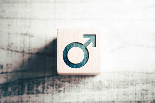 Znak płci męskiej na drewnianym bloku na stole — Zdjęcie stockowe