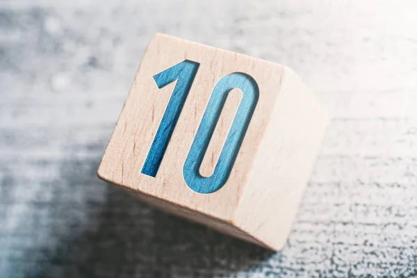 Número 10 em um bloco de madeira em uma mesa — Fotografia de Stock