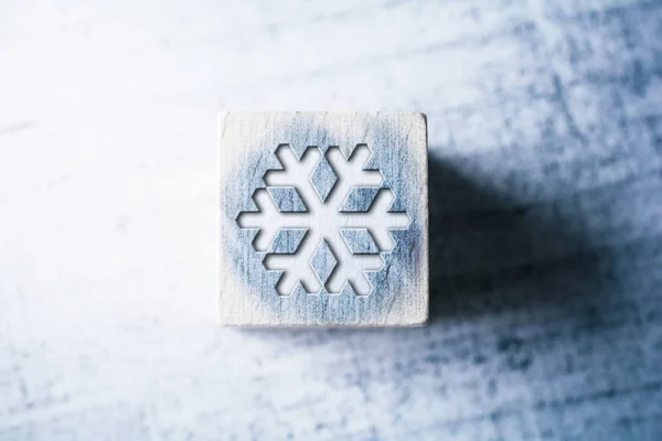 Panneau de flocon de neige sur un bloc en bois bleu sur une table — Photo