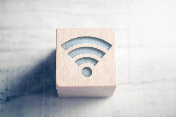 Macro de un icono de WIFI en un bloque de madera en una mesa —  Fotos de Stock