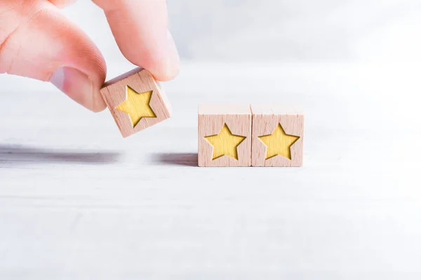 3 Star Ranking Formed By Wooden Blocks And Arranged By A Male Finger On A White Table — ストック写真