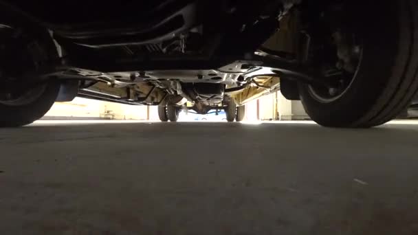 車の下 排気ガス カメラのズーム 車の下のビュー ガレージにチェック 車を通ってドライブ 車の修理 — ストック動画