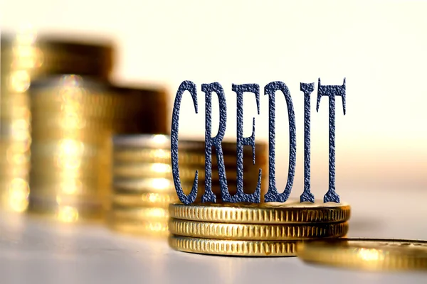 Het woord "credit" op de achtergrond de kolommen van de munten . — Stockfoto