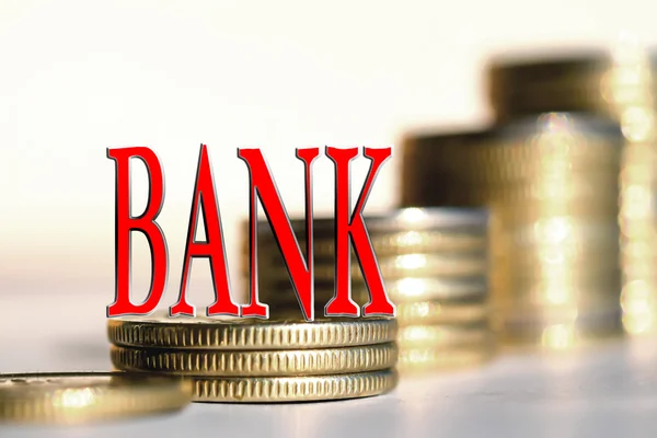 The word "Bank" in the background the columns of coins . — Stock Photo, Image