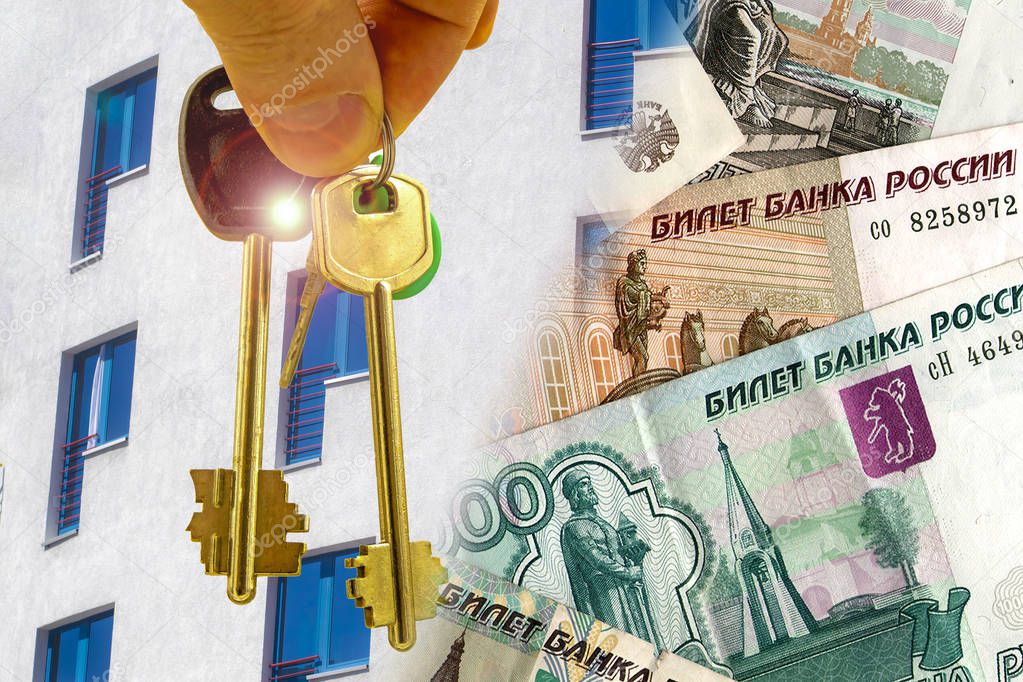 The keys to the apartment on a background of money and houses . 