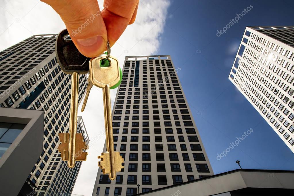 The keys to the apartment in the background of the facade of the house . 