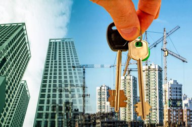 The keys on the background of the construction of new modern buildings .  clipart