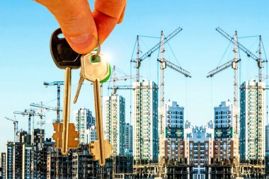 The keys on the background of the construction of new modern buildings . The concept of the development of urban construction . clipart