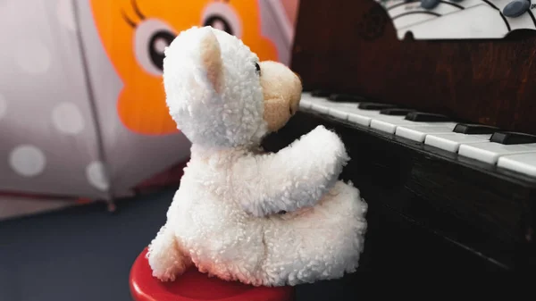 Urso Peludo Branco Pelúcia Senta Uma Cadeira Vermelha Toca Bebê — Fotografia de Stock