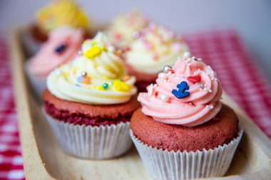 Taze tereyağı kremalı, beyaz ve gül soslu kırmızı kadife kek. Çapa ya da ananas gibi küçük renkli serpintilerle birlikte. Her biri farklı bir odak noktasından. 