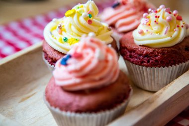 Taze tereyağı kremalı, beyaz ve gül soslu kırmızı kadife kek. Çapa ya da ananas gibi küçük renkli serpintilerle birlikte. Her biri farklı bir odak noktasından. 