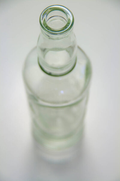 A large transparent bottle without contents against a white background. The focus is on the opening. Suitable for whisky and rum. 