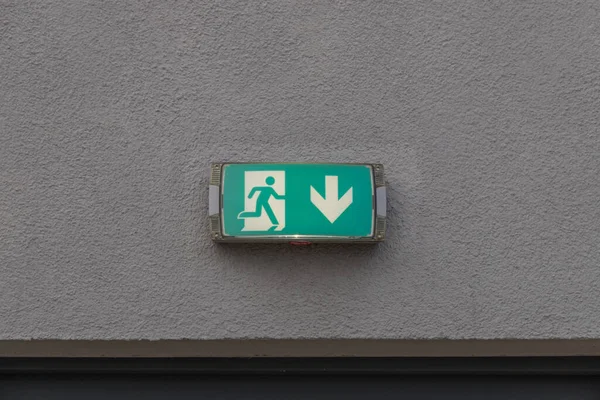 this sign on a wall shows the escape route with an arrow