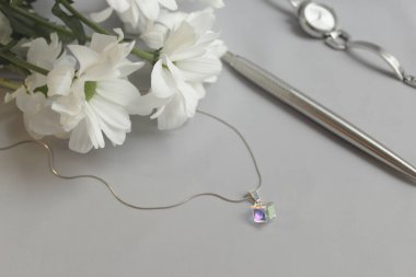 Çiçekli bir masada Swarovski kristal kolye