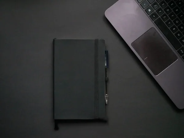 Irodai felülnézet. Laptop, toll és notebook fekete háttér. — Stock Fotó
