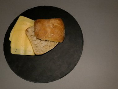 Siyah tabakta dilimlenmiş ekmek ve gri arka plan