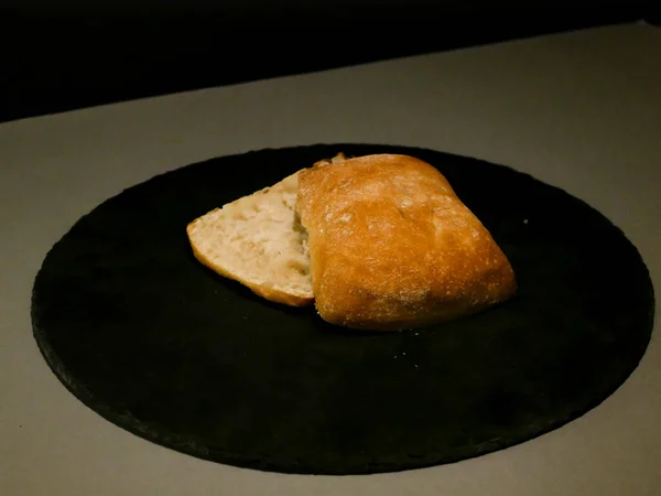 Pan rebanado en plato negro . — Foto de Stock