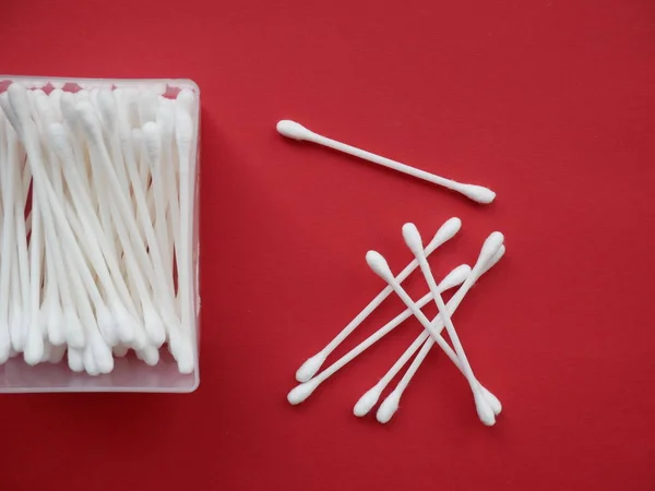 Flat lay composition with cotton swabs on red background. Top view ear sticks.