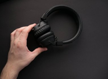 Renkli kağıt arka planda klasik kablosuz kulaklıklar. Retro tarzı. 80 'ler. Popüler kültür. Üst Manzara. Minimal Müzik Konsepti. Ellerini tut.