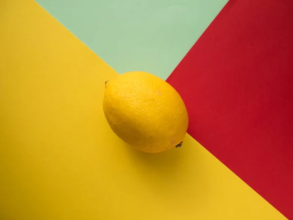 Lemon on a colored background, top view. Trendy colorful photo. Minimal style with colorful paper backdrop. Flat lay fashion concept: lemon on pastel background.