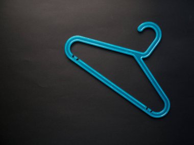 Pastel siyah arka planda mavi plastik askı. Alışveriş, satış, tanıtım, sosyal medya, yeni sezon konsepti