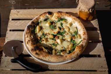 Peynirli, ıspanaklı ve armutlu ev yapımı pizza.