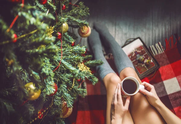 Ayak kız ile bir fincan el çorap ve Noel ağacı giyinmiş