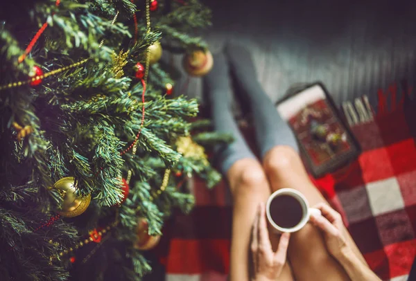 Ayak kız ile bir fincan el çorap ve Noel ağacı giyinmiş