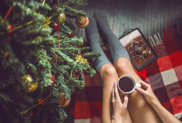 Ayak kız ile bir fincan el çorap ve Noel ağacı giyinmiş