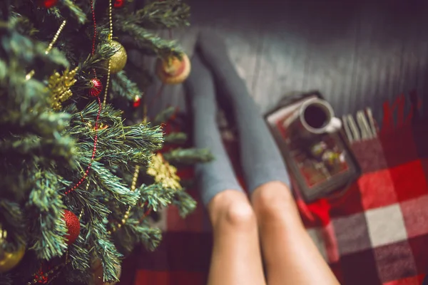 Ayak kız ile bir fincan el çorap ve Noel ağacı giyinmiş