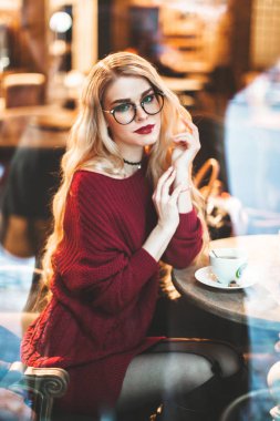 Sarışın kız gözlüklü, gülümseyen bir bordo kazak, kar, kış