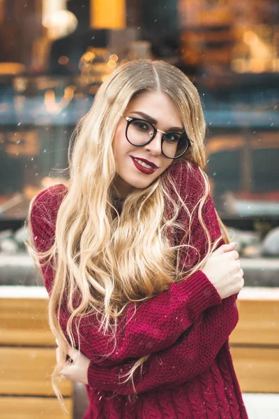 Ξανθιά κοπέλα με τα γυαλιά, χαμογελώντας σε Μπορντό πουλόβερ, χιόνι, χειμώνα — Φωτογραφία Αρχείου
