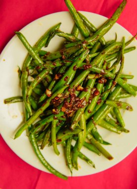 Taze organik pişmiş fasulye bir kase kırmızı nupkin üzerinde