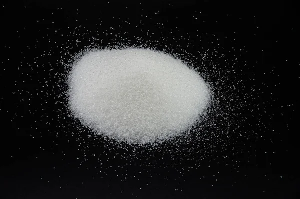 Spilled sugar on a black background — Stock Photo, Image