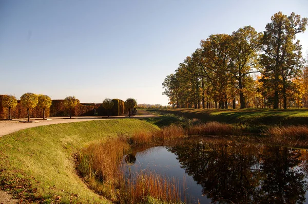 stock image Autumn in a beautiful park with a pond, road