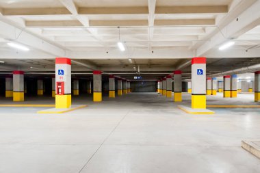 Kırmızı ve sarı kolonları olan tamamen boş bir otopark.