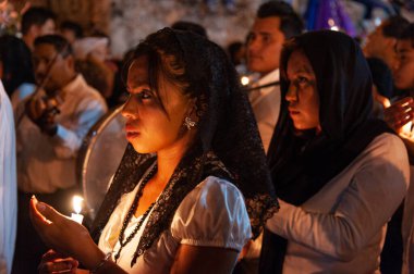 Taxco, Meksika, 18 Nisan 2011: Taxco, Meksika 'da dini bir Paskalya etkinliğinde mum taşıyan ve başörtüsü takılan kız.