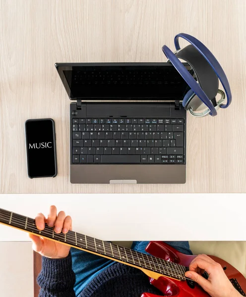 Learning music from home with laptop and mobile phone, with red guitar and headphones, black background screens