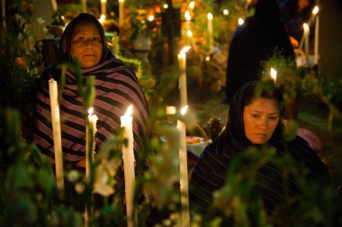 Patzcuaro, Meksika, 1 Kasım 2011: Ölüler gününde mumlar ve çiçeklerle ölüleri izleyen yaşlı kadınlar
