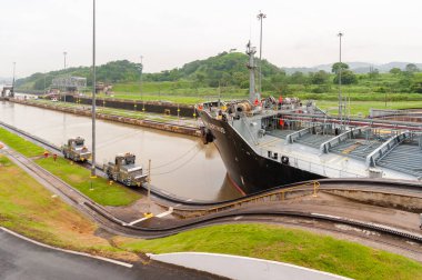 Panama Kanalı 'ndaki siyah kargo gemisi lokomotiflerle çekildi.
