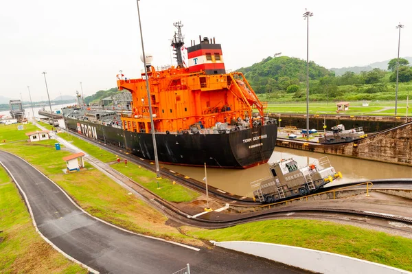 Panama 'daki turuncu kargo gemisinin arkasında çekme makineleri var.