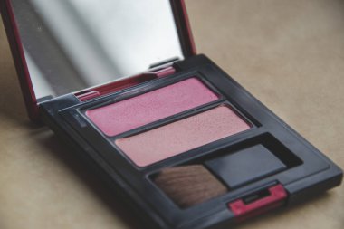 İçinde küçük bir kızarıklık olan iki allık resminin yakın çekim görüntüsü. Küçük aynalı kadınlar için kozmetik ürünler. Hanımlar için güzellik. Yanaklar için pudra. 