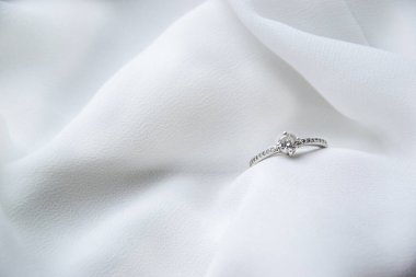 Beyaz ipeksi arka planda Macro nişan yüzüğünün resmi düğün kartı konsepti arka plan duvar kâğıdı ve ona romantik zamanlarda moda tarzı olarak evet demesi için hediye.