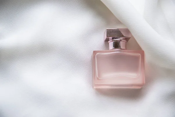 Imagen Cerca Una Pequeña Botella Perfume Rosa Situada Fondo Sedoso — Foto de Stock