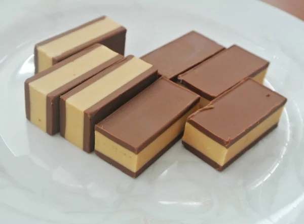 Nahaufnahme Von Schokolade Nougats Auf Weißer Untertasse Isoliert Auf Weißem — Stockfoto